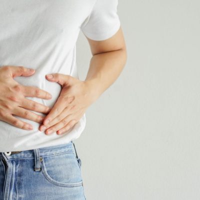 close up adult man hand massage on stomach after got pain feeling on white background fro healthy and lifestyle concept