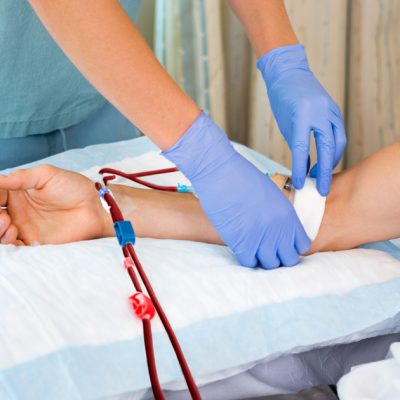 Nurse in renal unit at hospital starting dialysis on patient